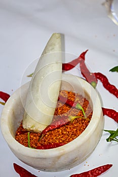 Hot dry red chilli pepper and powder in a motor pestle