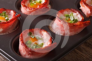 Hot eggs wrapped in bacon close up in baking dish. Horizontal