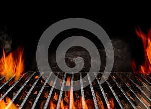 Hot empty portable barbecue BBQ grill with flaming fire and ember charcoal on black background. Waiting for the