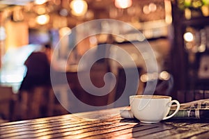 Hot espresso coffee cup with newspaper on wooden table lighting