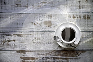 Hot espresso coffee cup on rustic wooden table with sunlight in summer morning  background