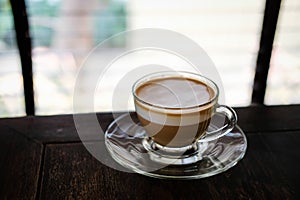 hot espresso macchiato coffee with milk topping in glass cup on