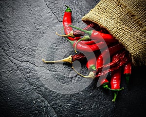 Hot and fresh red pepper in a bag. Dark stone background from slate.