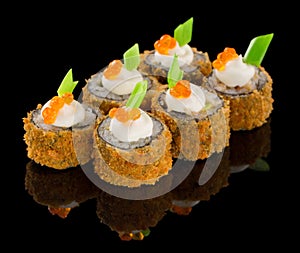 Hot Fried Futomaki Sushi roll with sauce, caviar and chive ot top isolated on black background with reflection