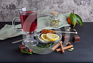 Hot fruit tea with lemon on the dark surface, copy space