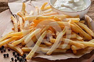 Hot golden french fries with ketchup on a wooden background. Tasty american fast food