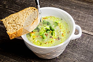 Hot green peas soup on the rustic background