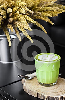 Hot green tea latte with green on wooden