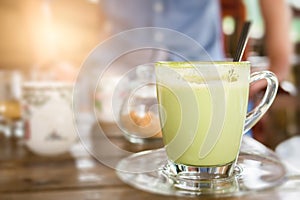 Hot green tea milk in glass mug.