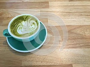 Hot green tea on wood background.