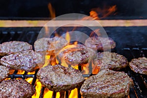 On the hot grill, a barbecued American beef burger is being grilled on the flames