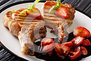 Hot grilled tasty pork chop with balsamic strawberry close-up on