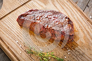 Hot Grilled Whole DenverHot Grilled Whole Denver Steak on Wooden Board with Herbs. Fresh Juicy Medium Rare Beef