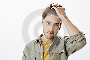 Hot guy getting interested in attractive woman on party. Indoor shot of charming bearded male with blue eyes, biting lip