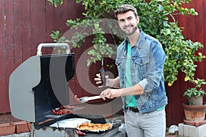 Hot guy preparing dinner in barbecue