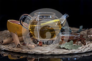 Hot herbal tea with lemon slice in a in a tea pot on a woodentable, close up, still life photography