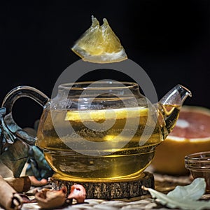 Hot herbal tea with lemon slice in a in a tea pot on a woodentable, close up, still life photography