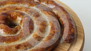 Hot homemade sausage lies on the cutting board. Baked sausage in the oven on a wooden board. BBQ meat dishes. Grilled