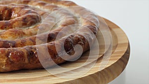 Hot homemade sausage lies on the cutting board. Sausage on a wooden board. Barbecue meat dishes Grilled sausages