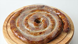 Hot homemade sausage lies on the cutting board. Sausage on a wooden board. Barbecue meat dishes Grilled sausages