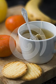 Hot infusion with tangerines and butter cookies over wooden table