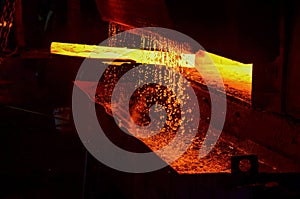 Hot iron in smeltery held by a worker. Melting of metal in a steel plant