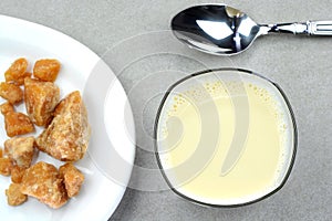 Hot jaggery milk in a glass cup