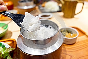 hot Japanese rice served in an old style rice cooker was pick with plastic rice paddle.