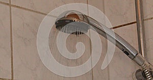 A hot jet of water flows from the chrome-plated shower head in the bathroom