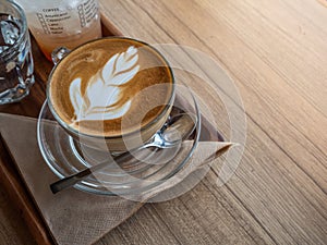Hot latae coffee on wood trey. Wood table top