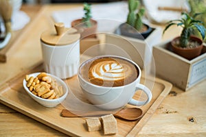 hot latte art with cactus in coffee shop on table wooden