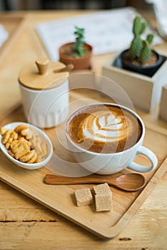 hot latte art with cactus in coffee shop on table wooden