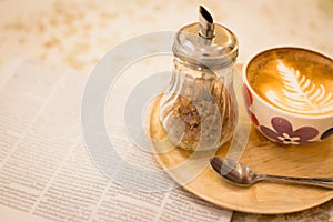 hot latte art coffee with newspaper on wooden table, vintage and