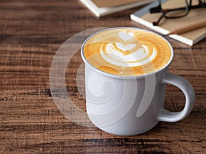 Hot latte coffee with art heart shape in grey ceramic mug.