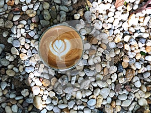 Hot latte coffee in Double wall cup  on the stone floor with natural light. Vacation time.