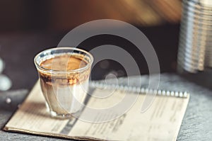 Hot latte coffee in glass on wooden table at coffee shop