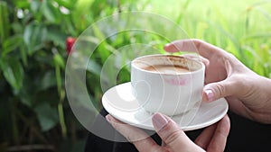 Hot latte coffee in green tropical garden for girl
