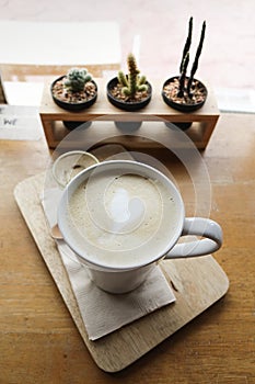 Hot latte coffee on wooden plate