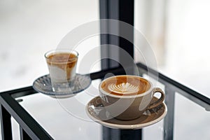 Hot Latte and Dirty Coffee - A cup of coffee with milk and beautiful leaf pattern latte art and A glass of espresso shot mixed