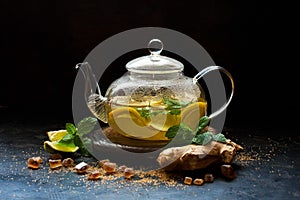 Hot  lemon and ginger  tea, rink in  glass teapot  with fresh mint  leaves