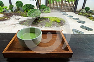 Hot macha milk green tea with traditional Japanese garden