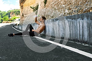 Hot Man Pouring Refreshing Water Over Face After Exercising Outdoors