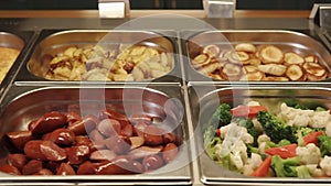 Hot meals lying in food trays.