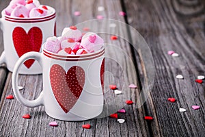 Hot milk with pink marshmallow in mugs with hearts for Valentine day