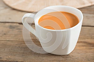 Hot milk tea in a white cup. Selective focus.