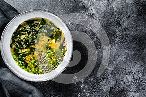 Hot miso soup in a bowl. Black background. Top view. Copy space