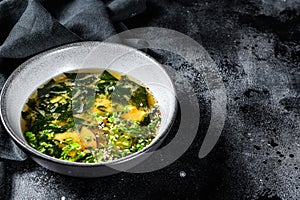 Hot miso soup in a bowl. Black background. Top view. Copy space