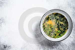 Hot miso soup in a bowl. White background. Top view. Copy space