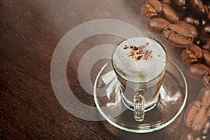 Hot mocha coffee with milk foam and cocoa powder on a wooden