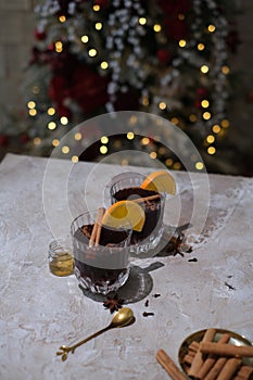 Hot mulled wine with orange, anise,cinnamon with fresh fruits on wooden table. Boceh light backgraund
